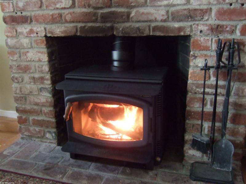 Zwarte houtkachel-insert met brandend vuur